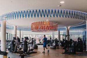 a man walking through a gym with a chandelier at New apartment in Higueron West in Fuengirola