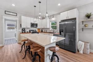 a kitchen with a large island with bar stools at Cozy Chic Home In Downtown Loveland! in Loveland