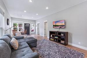 a living room with a couch and a tv at Cozy Chic Home In Downtown Loveland! in Loveland +35 photos