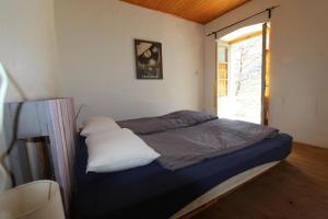 Ce lit se trouve dans une petite chambre dotée d'une fenêtre. dans l'établissement Camera in Casa Eva, à Brione