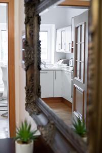 um reflexo de espelho de uma cozinha com um lavatório em Suzana Iron's apartment em Ljubljana