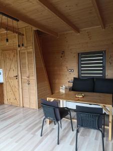 Habitación de madera con mesa y sillas en Chata z Kraja, en Pewel Wielka