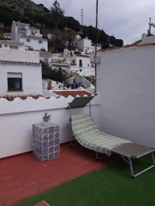 une chaise sur un balcon avec vue sur la ville dans l'établissement Piso De La Ermita, à Mijas