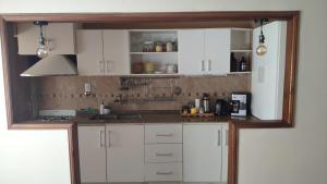 a kitchen with white cabinets and a counter top at Lo de Lucas in Olavarría