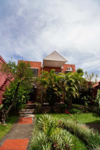 una casa con muchas plantas delante de ella en BORUKA BnB, en Alajuela