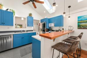 een keuken met blauwe kasten en een aanrecht met krukken bij Vibrant Downtown Bungalow - Walk Everywhere! in Fort Collins