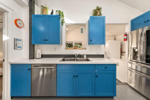 een keuken met blauwe kasten en een wastafel bij Vibrant Downtown Bungalow - Walk Everywhere! in Fort Collins