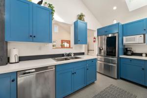 een keuken met blauwe kasten en roestvrijstalen apparatuur bij Vibrant Downtown Bungalow - Walk Everywhere! in Fort Collins