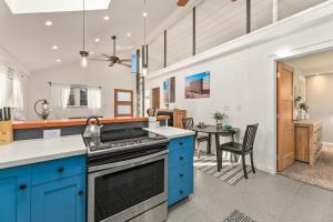 een keuken met blauwe kasten en een eetkamer bij Vibrant Downtown Bungalow - Walk Everywhere! in Fort Collins +26 foto's