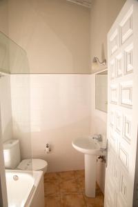 Baño blanco con aseo y lavamanos en Apartamentos El Patio, en Lerones