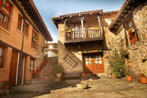 un edificio de piedra con balcón y puerta en Apartamentos El Patio, en Lerones