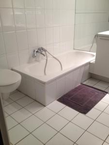 a bath tub with a faucet in a bathroom at Bruges Grande Place Guesthouse in Bruges