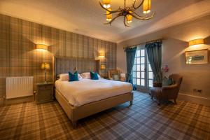 a bedroom with a large bed and a chandelier at Washingborough Hall Hotel in Lincoln