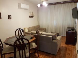 - un salon avec un canapé et une table dans l'établissement Apartamento em frente a Praia do Embaré - Santos, à Santos