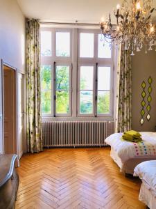 een slaapkamer met een bed en een groot raam bij Château Fauchey in Cardan