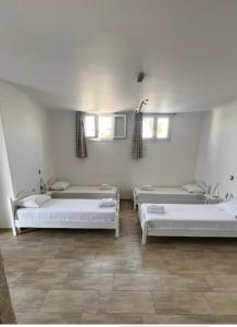 a room with three beds and a sink at Katerina Apartments & Studios in Naousa