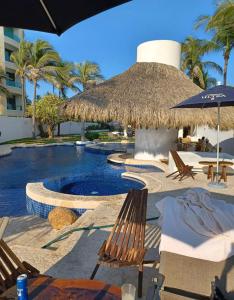 een resort met een zwembad met stoelen en parasols bij Depa de lujo en Acapulco diamante sin daños por huracán Otis-Precio especial in Acapulco