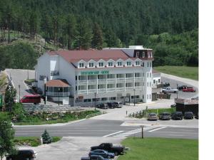 a large white building with cars parked in a parking lot at Roosevelt Inn Mount Rushmore in Keystone