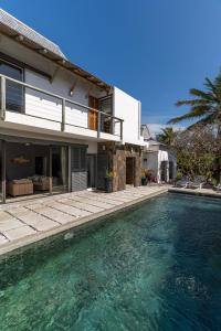 a house with a swimming pool in front of a house at Koki Bonheur by muse villas in Poste Lafayette