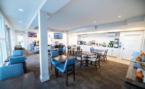 ein Esszimmer mit Tischen und Stühlen und eine Küche in der Unterkunft Days Inn by Wyndham Bar Harbor in Bar Harbor
