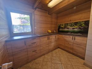 a kitchen with wooden cabinets and a window at Hostel Regionalny in Zakopane