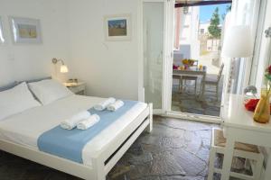 1 dormitorio con 1 cama con toallas en Playera Bungalow G sea view, en Naousa