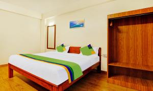 una camera da letto con un letto bianco con una coperta arcobaleno di Treebo SS Residency With Mountain View a Dapoli