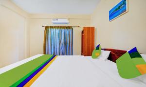una camera da letto con un letto bianco con lenzuola colorate di Treebo SS Residency With Mountain View a Dapoli