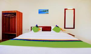 una camera da letto con un letto bianco e una coperta arcobaleno di Treebo SS Residency With Mountain View a Dapoli