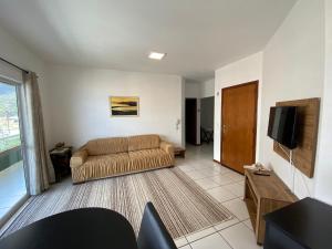 a living room with a couch and a flat screen tv at 2 Dormitórios Vista Mar in Itapema