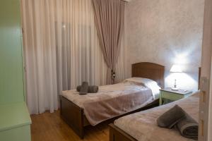 een hotelkamer met 2 bedden en een raam bij Casa Nostra in Aridaía