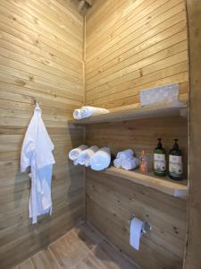 a sauna with wooden walls and towels and bottles at Caralsol Glamping in Rionegro