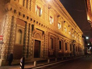 a building at night with a person standing in front of it at TL Palazzo Fantuzzi in Bologna