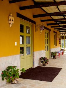 un edificio amarillo con una puerta verde y un banco en Tambo Sapalanchan, en Lamud