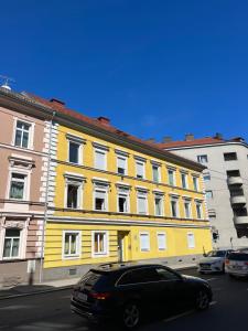 a black car parked in front of a yellow building at Rudolfquartier Linz, Rudolfstraße in Linz