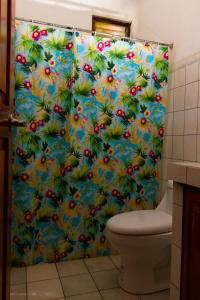 a bathroom with a shower curtain with flowers on it at BORUKA BnB in Alajuela