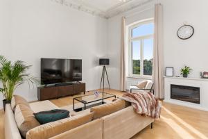 un soggiorno con divano e TV di HOMEY Apartments - Riverside - mit Weserblick und Parkplatz a Brema