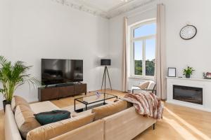 ein Wohnzimmer mit einem Sofa und einem TV in der Unterkunft HOMEY Apartments - Riverside - mit Weserblick und Parkplatz in Bremen