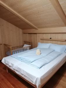 a large white bed in a room with wooden ceilings at Casa Heidi in Pieve di Cadore