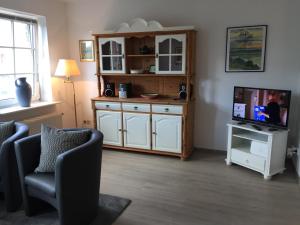 a living room with two chairs and a television at Fischerstuuv in Husum