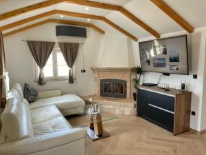 a living room with a white couch and a fireplace at Villa LONGO in Supetar