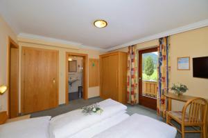 a hotel room with two beds and a television at Hotel Garni Bergwelt in Sankt Anton am Arlberg