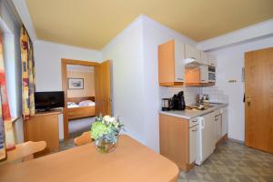 a kitchen with a table with a vase of flowers on it at Hotel Garni Bergwelt in Sankt Anton am Arlberg +17 photos