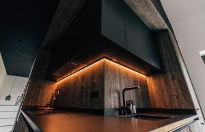 a kitchen with a sink and lights on the wall at Comme chez Lore - villa 2pers - piscine chauffée in Namur