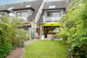 Cette maison dispose d'une terrasse avec un parasol. dans l'établissement Weidenweg 37, à Grömitz