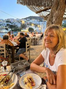 een vrouw die aan een tafel zit met een bord eten bij Aegean Dream 2 in Panteli