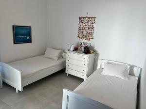 een slaapkamer met 2 bedden en een dressoir. bij Aegean Dream 2 in Panteli