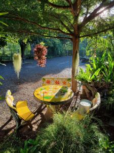 stół i krzesła siedzące pod drzewem w obiekcie Baandin resort w mieście Sukhothai