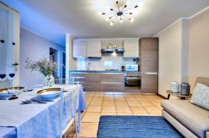 eine Küche und ein Wohnzimmer mit einem Tisch und einem Sofa in der Unterkunft DIMORA SAN LORENZO in Maggio