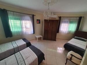 1 dormitorio con 2 camas y lámpara de araña en APARTMENT AYOUB -for families only-, en Nador
